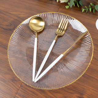 Elegant clear plate with gold trim and gold-accented cutlery set.