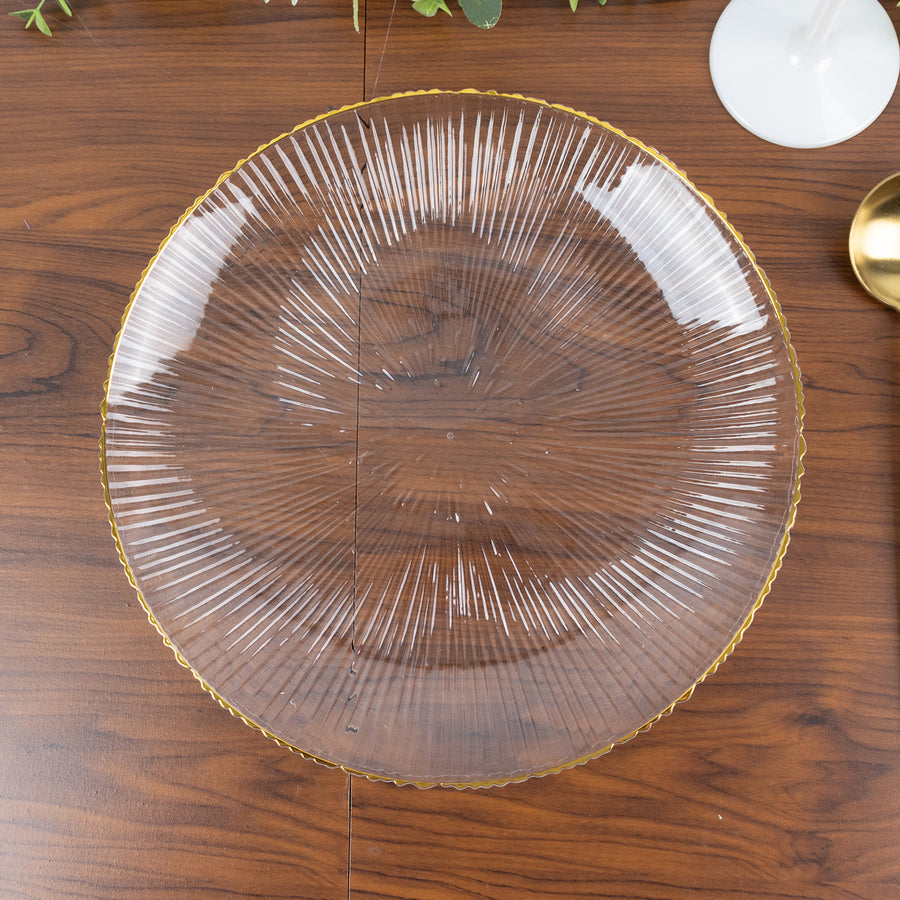Clear glass plate with textured lines and gold rim on wooden surface.