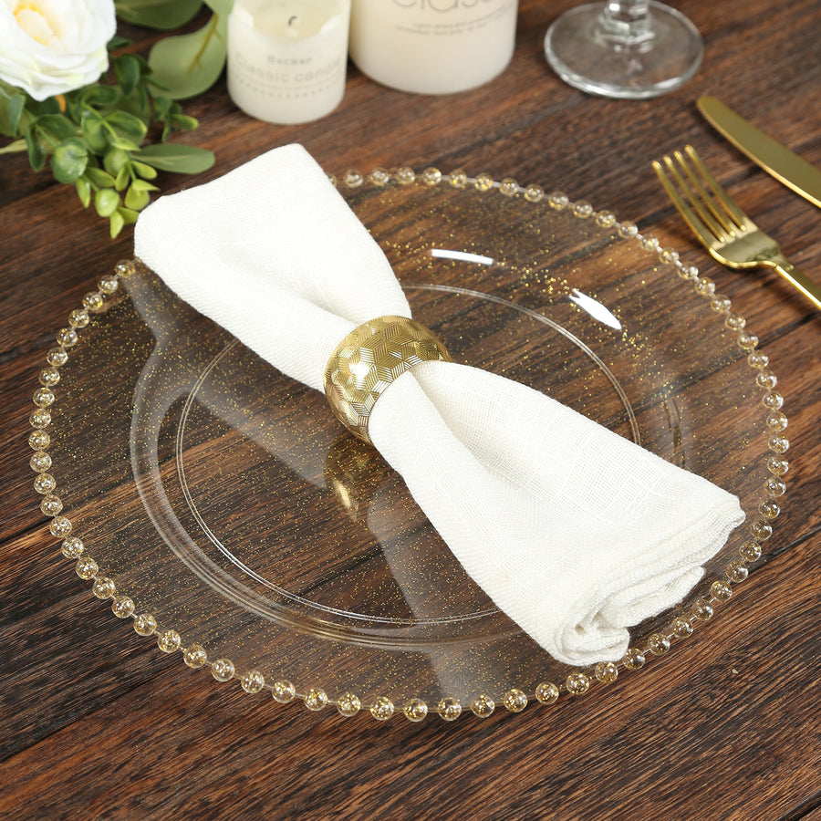 Elegant table setting with a gold napkin ring on a clear plate.