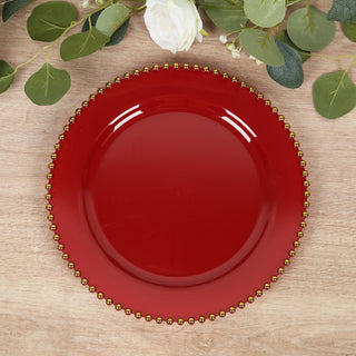 Red decorative plate with gold beaded rim on a wooden surface.