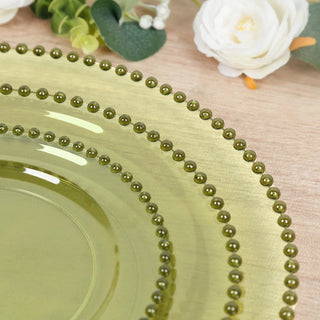 Green decorative plate with beaded edge on a textured surface.