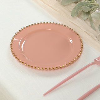 Pink decorative plate with gold bead trim on a light background.