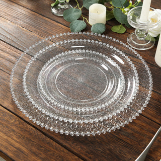 Clear decorative plates stacked on a rustic wooden table.