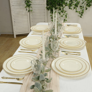 Elegant dinner table setting with gold-accented plates and candles.