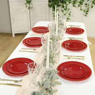 Elegant red dinner plates set on a beautifully arranged dining table.