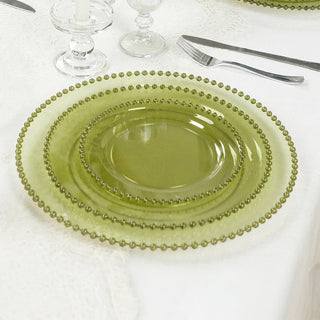 Elegant green glass plates set on a dining table with cutlery.
