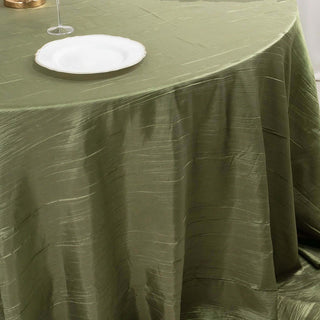Olive green tablecloth draped elegantly over a table with a white plate.