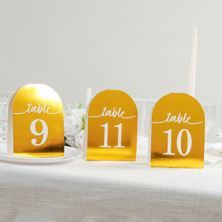 Gold table numbers 9, 10, and 11 with elegant white text on a dining table.
