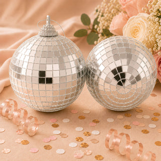 Silver disco ball ornaments with mirrored tiles on a peach floral background