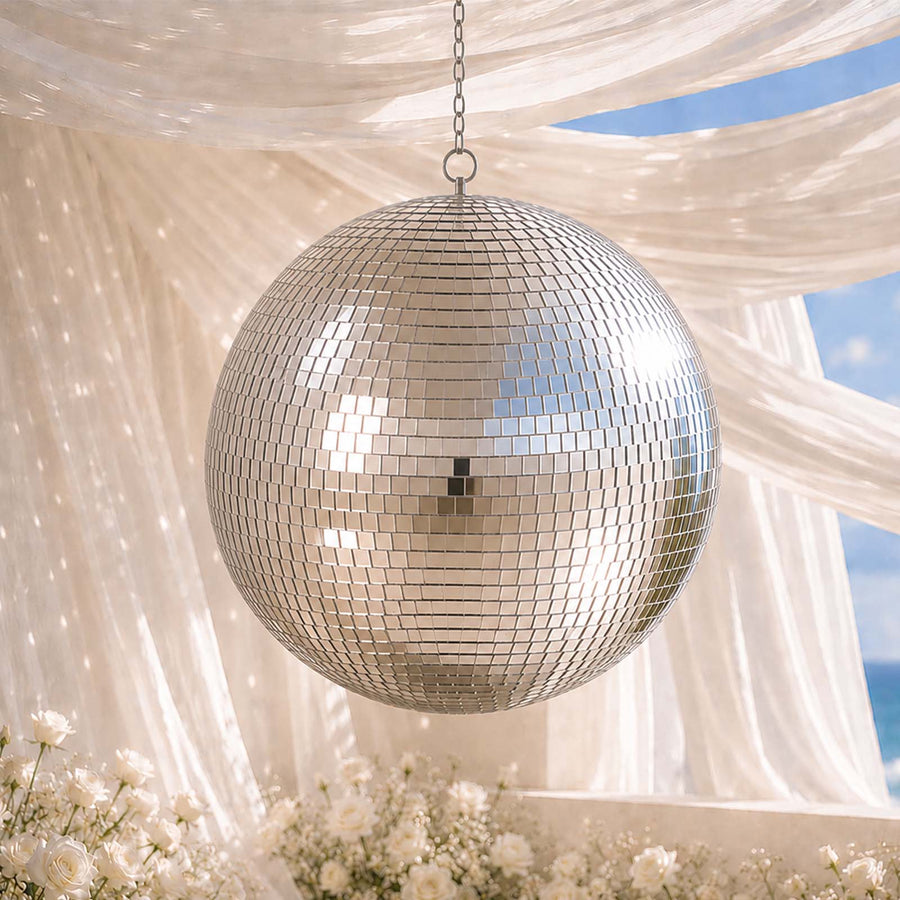 Hanging mirror disco ball under sheer drapes with white flowers and blue sky