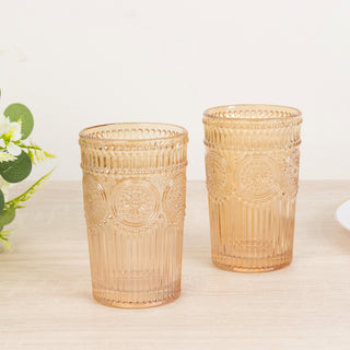 Two vintage-style amber glass cups on a wooden table.