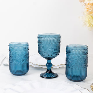 Three elegant blue glass cups with textured designs on a white background.