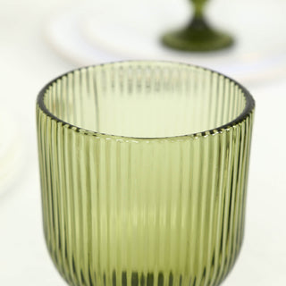 Olive green ribbed glass tumbler on white background