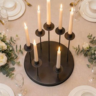Elegant black candle centerpiece on a wedding reception table with floral decor