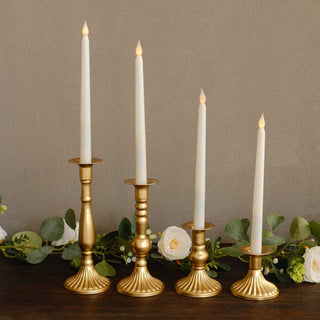 Elegant gold candle holders with white candles, set on a wooden surface.