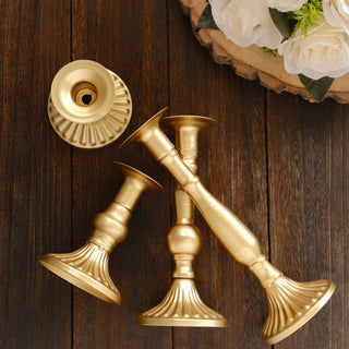Gold candle holders arranged on a wooden surface.