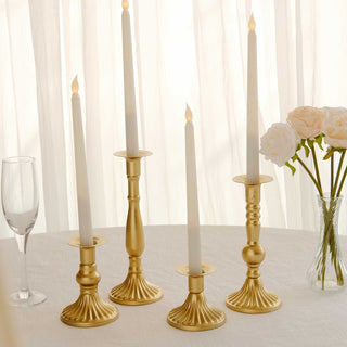 Gold candlestick holders with white candles on a table