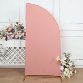 Pink curved backdrop with floral arrangement, studio setting.