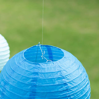 Blue paper lantern hanging outdoors against a blurred green background.