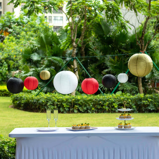 Colorful paper lanterns hanging above a garden party table with decorations.