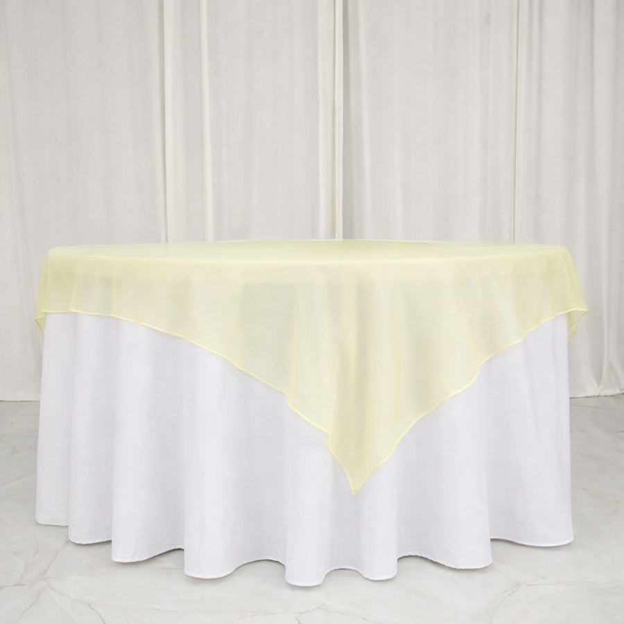 Yellow sheer table overlay on a white tablecloth.