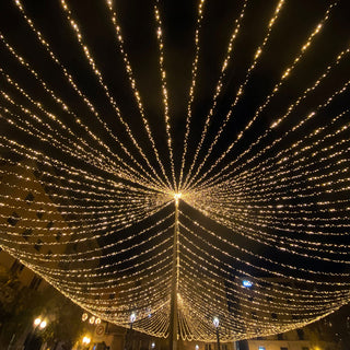 Decorative string lights illuminating a night sky in a festive display.