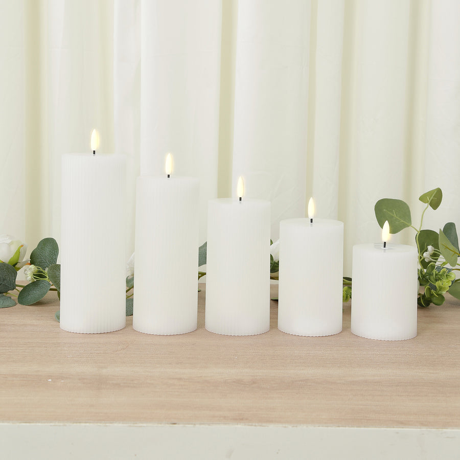 Set of five white pillar candles with realistic flickering flames.