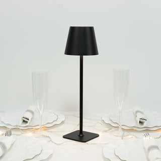 Modern black table lamp on a dining table with elegant glassware.