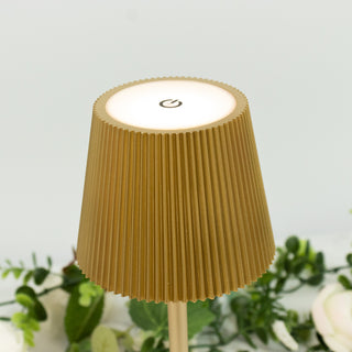 Gold ribbed lamp with a power button on a white background.