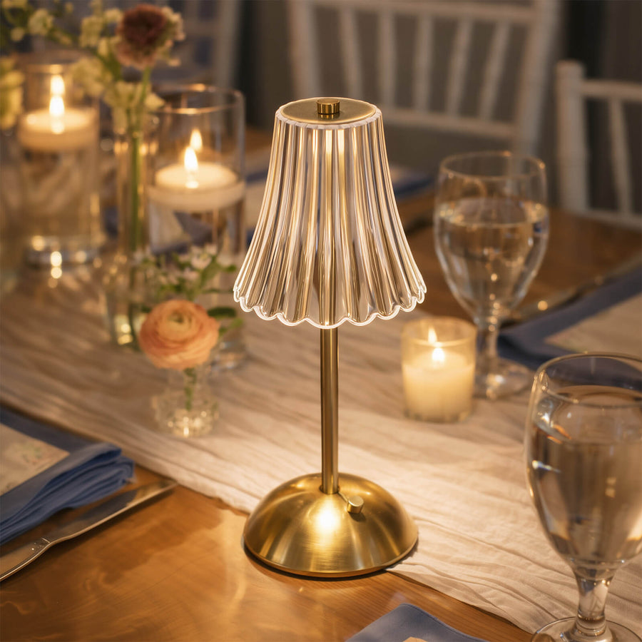 Gold pleated cordless table lamp on elegant candlelit dining table