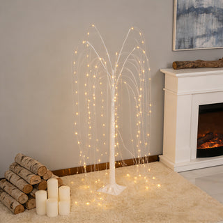 Lighted willow tree decoration with glowing branches in a cozy indoor setting.