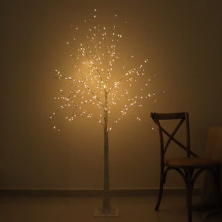 Illuminated decorative tree with lights in a dimly lit room.