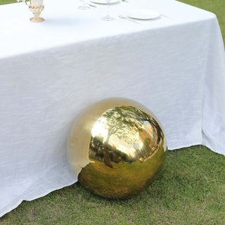 Gold decorative sphere under a white tablecloth in an outdoor setting.