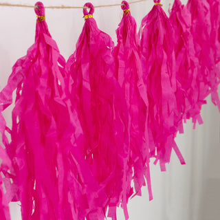 Pink tissue paper tassels on a string for party decorations.