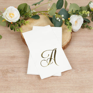 Personalized gold initial napkins on a wooden slice with greenery and flowers.