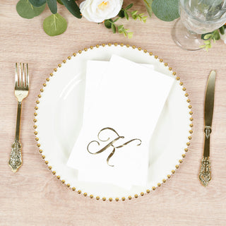 Elegant white plate with gold beaded rim, napkin and initial "K" setting.