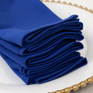 Folded blue napkins stacked neatly on a decorative plate.