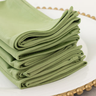 Stack of folded green napkins on a decorative plate.