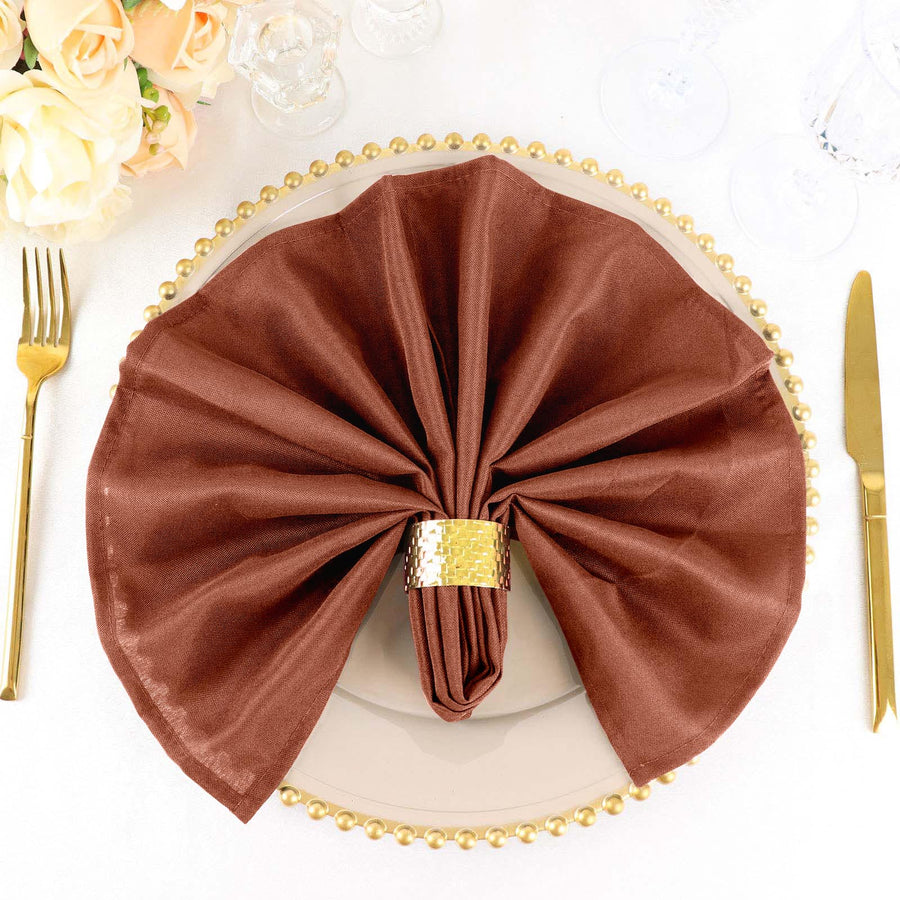 Elegant brown napkin elegantly folded on a decorative plate with golden accents.