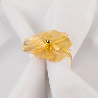 Gold flower napkin ring on a white napkin.