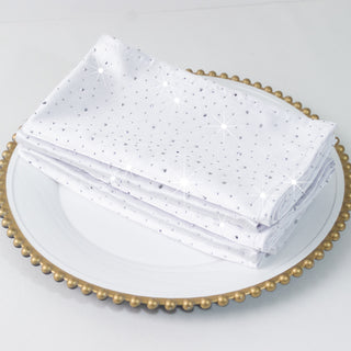 Sparkly white napkins stacked on a decorative plate.