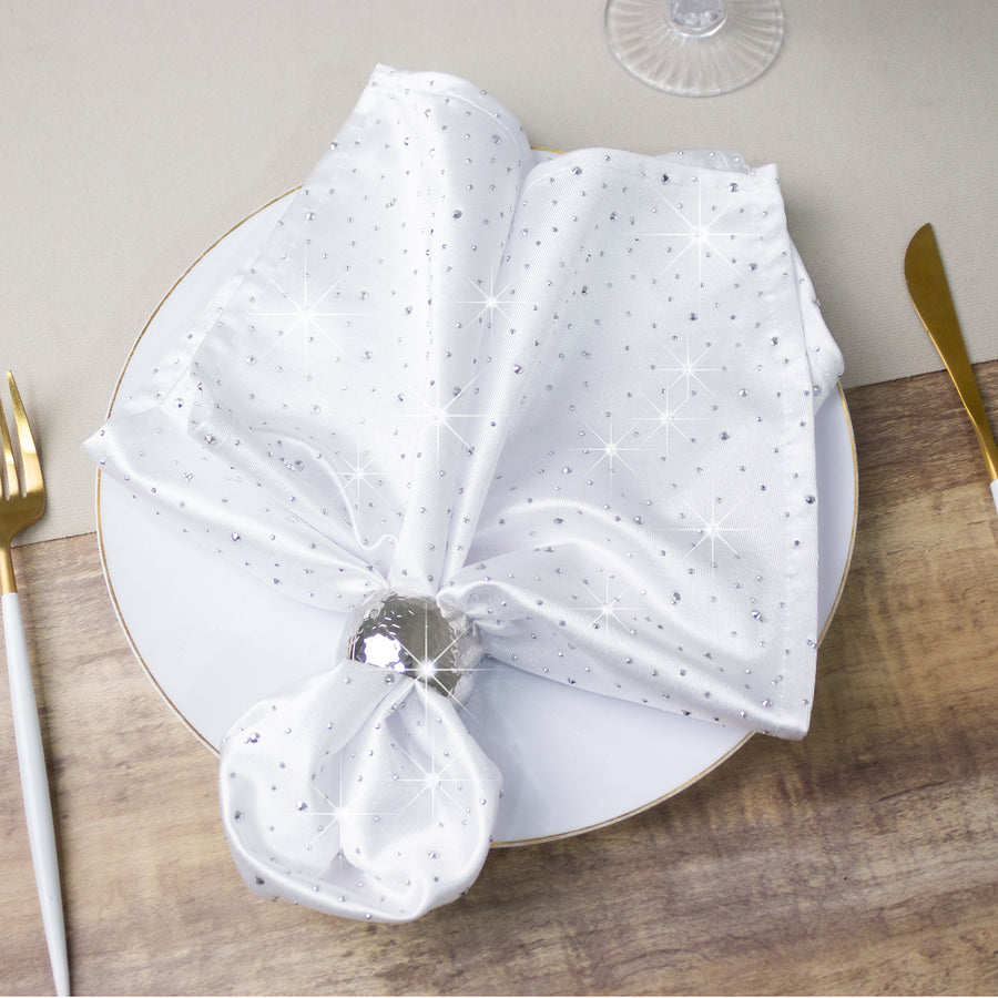 Elegant white napkin with silver star pattern, styled on a dinner plate.
