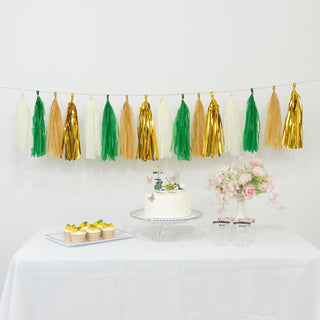 Colorful tassel garland decoration with cake, cupcakes, and flowers on a table.