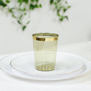 Transparent gold-rimmed cup on a white plate with elegant decor.
