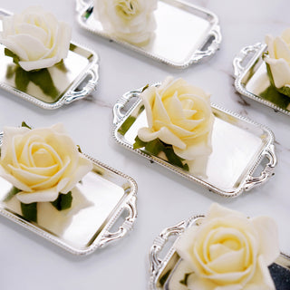 Elegant silver trays with white roses on a marble surface.