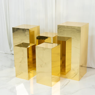 Gold geometric pedestals arranged in a modern display