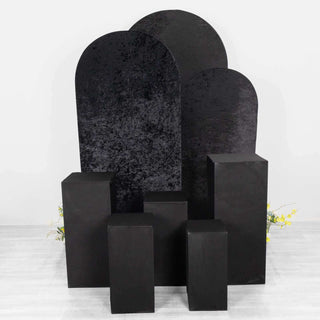 Black display stands in various shapes and heights on a white backdrop.