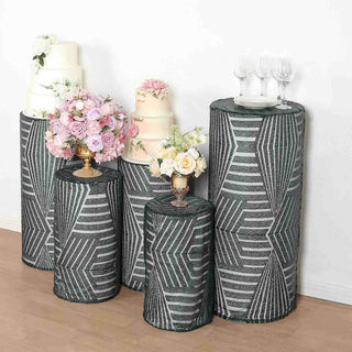 Decorative table covers in geometric pattern with floral arrangements and cakes.