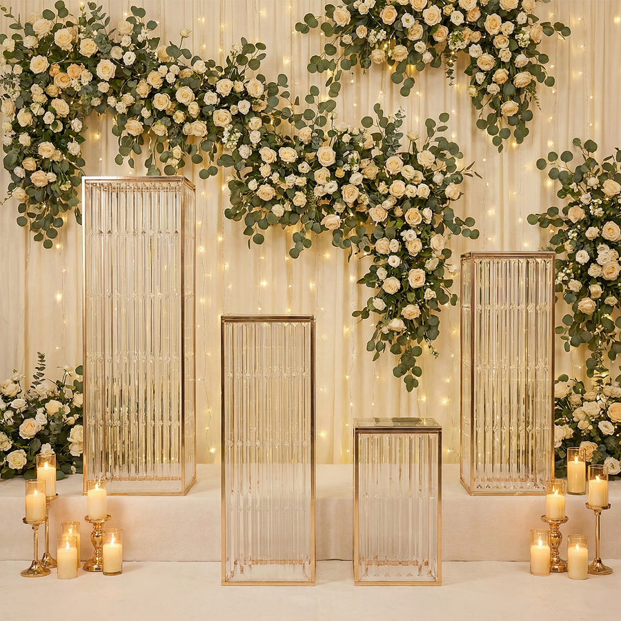 Elegant glass display pedestals adorned with floral backdrop and soft lighting.