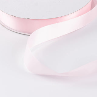 Pastel pink satin ribbon on white background